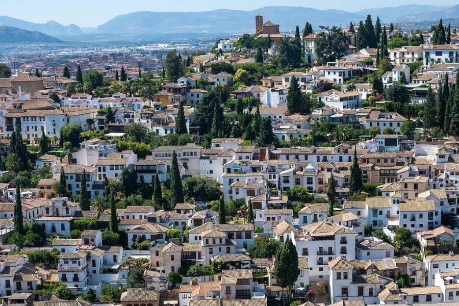 Panoramic view of Granada's Albaicín with traditional Andalusian white houses and cypress trees