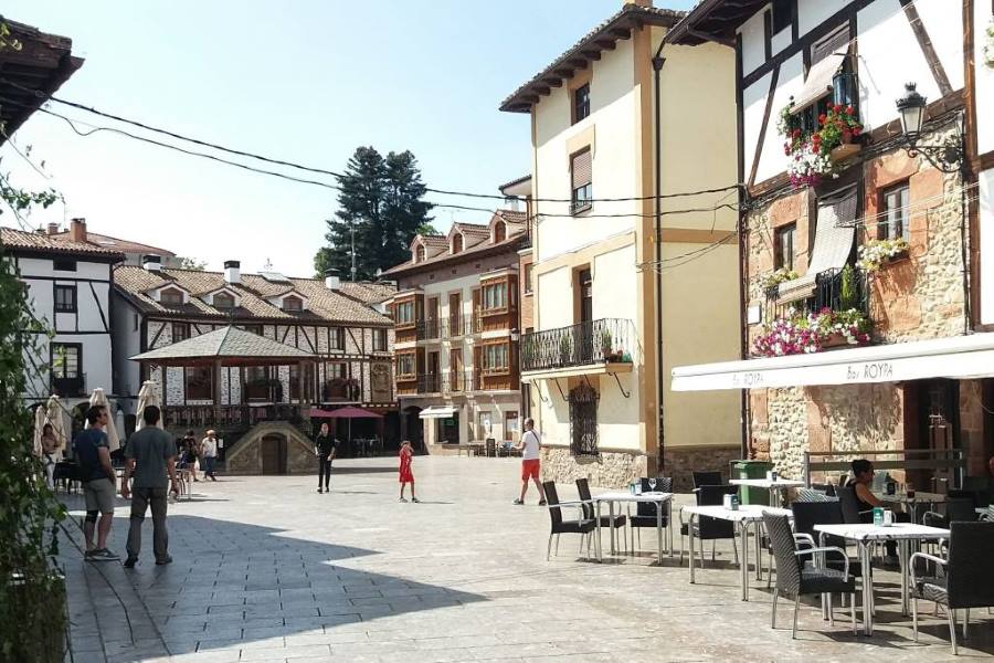 Sunny plaza in Ezcaray, La Rioja, with timber-framed houses, flowered balconies and outdoor cafés